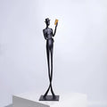 Black cast aluminium sculpture of a woman reading, measuring 51cm tall on a desktop.
