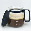 Transparent borosilicate glass coffee maker with a black silicone cover on a wooden table.