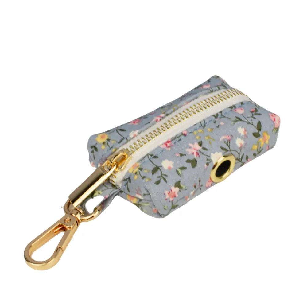 Blue floral pattern dog collar set with matching leash, vest, and accessories on white background