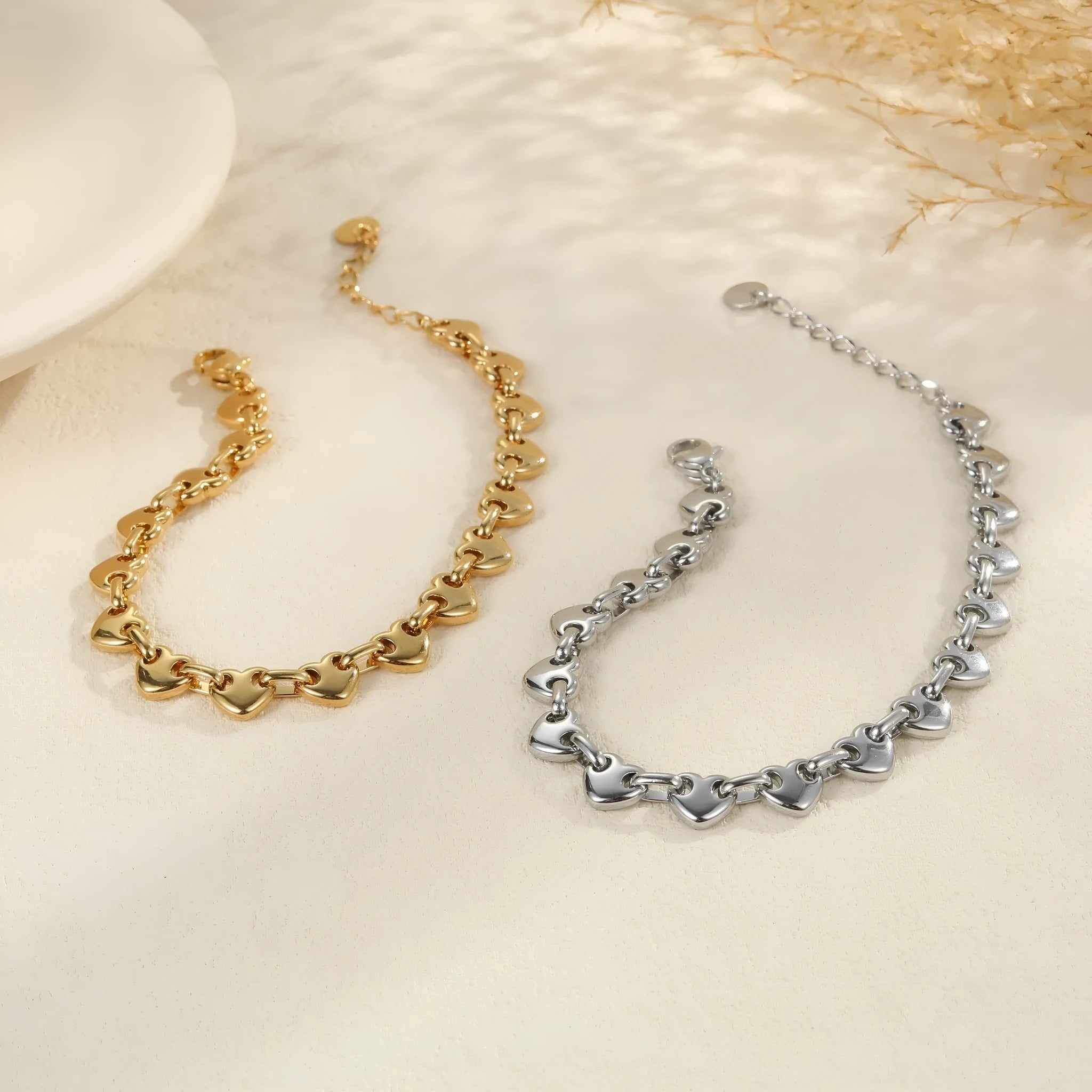 Stainless steel women's bracelet with hollowed-out heart design in gold or steel finish.