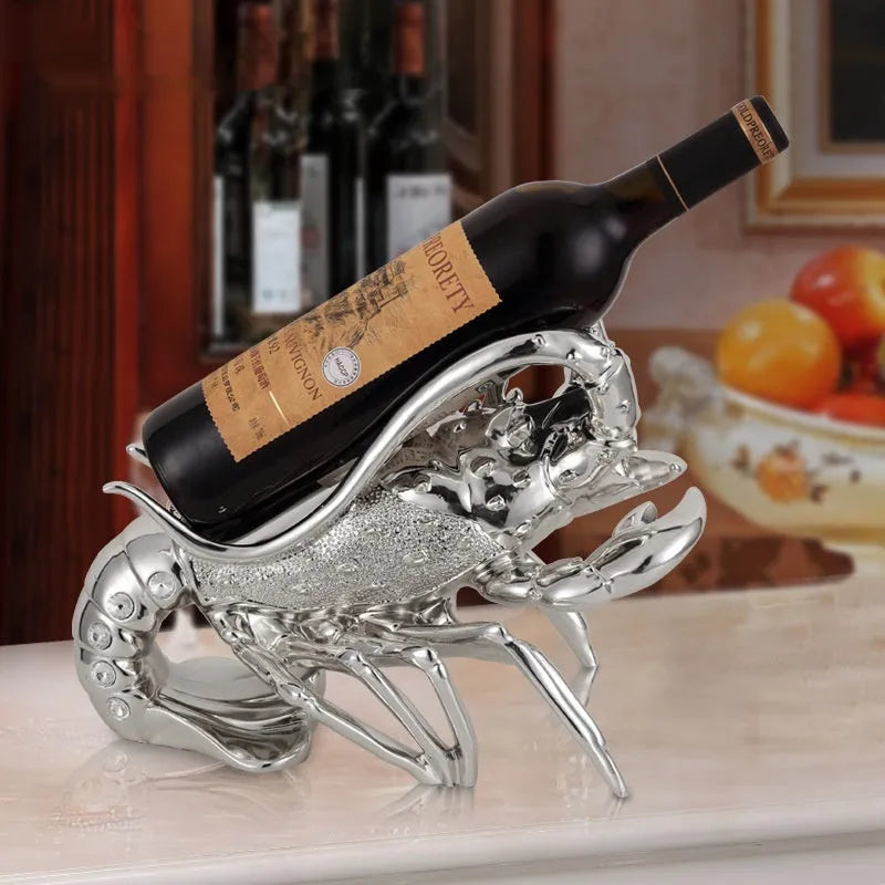Lobster-shaped natural resin wine rack ornament in rose gold or silver colour on a table.