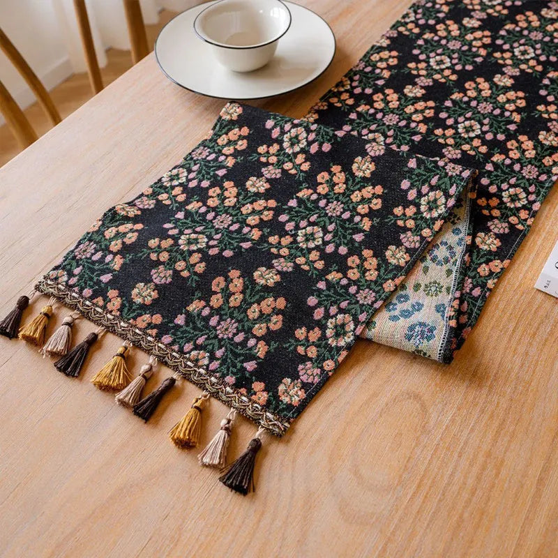 Dark blue Nordic jacquard stripe table runner with bouquet pattern and tassel fringe on a wooden table