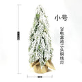 Small 24-inch artificial Christmas tree with white PE snow spray finish, green branches, built-in lights, and a red ornament