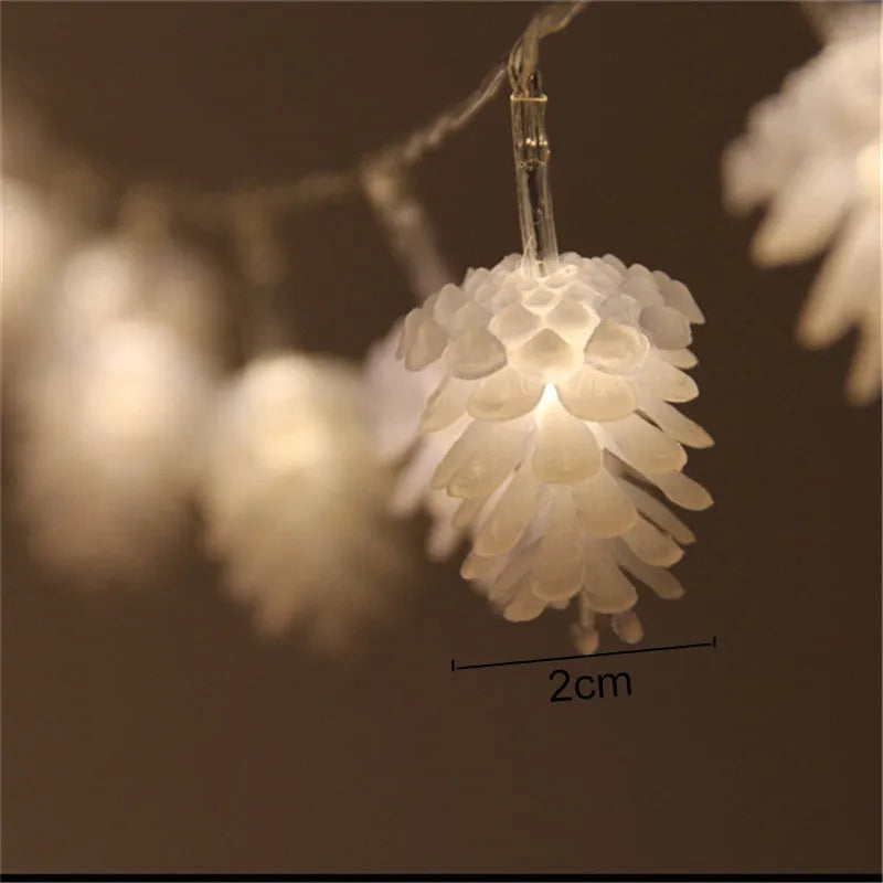 Warm white LED pine cone fairy light string on a green pine branch for decorative lighting