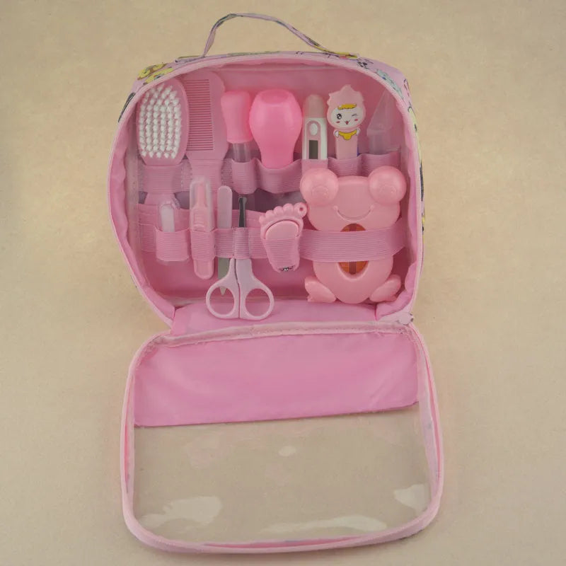 13-piece newborn baby care kit with pink grooming bag containing thermometer, scissors, brush, comb, nail clipper, and medicine tools