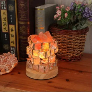 Himalayan crystal salt lamp with dimmer switch on wooden base emitting warm amber glow