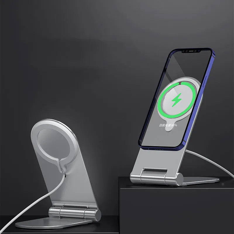 Silver vertical adjustable magnetic phone bracket for iPhone 12 models on a desk.