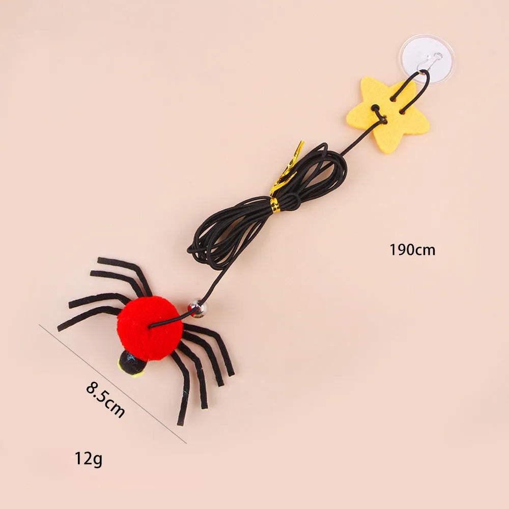 Red cat toy hanging from door with elastic rope, feather stick, bell, and spider decoration