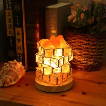 Himalayan crystal salt lamp with dimmer switch on wooden base emitting warm amber glow