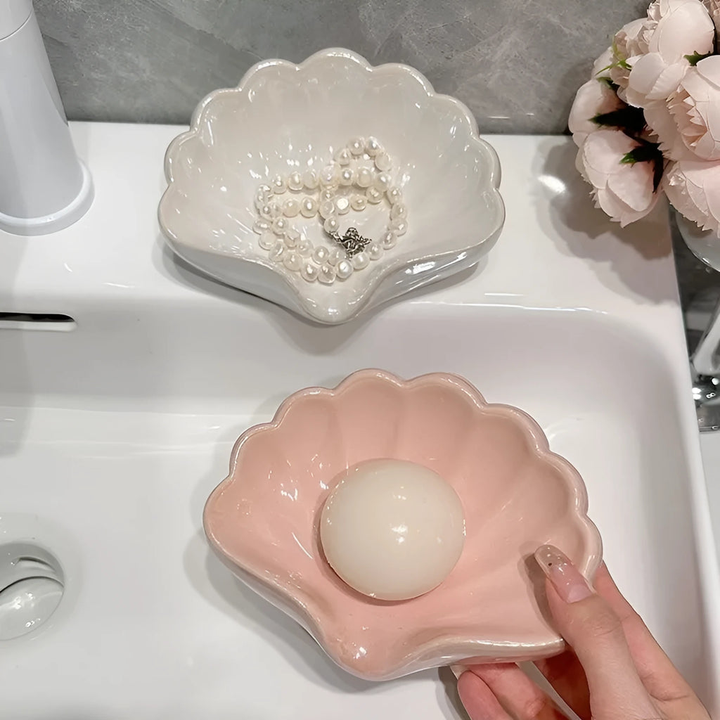 White and pink shell-shaped plastic soap dishes for bathroom countertops.