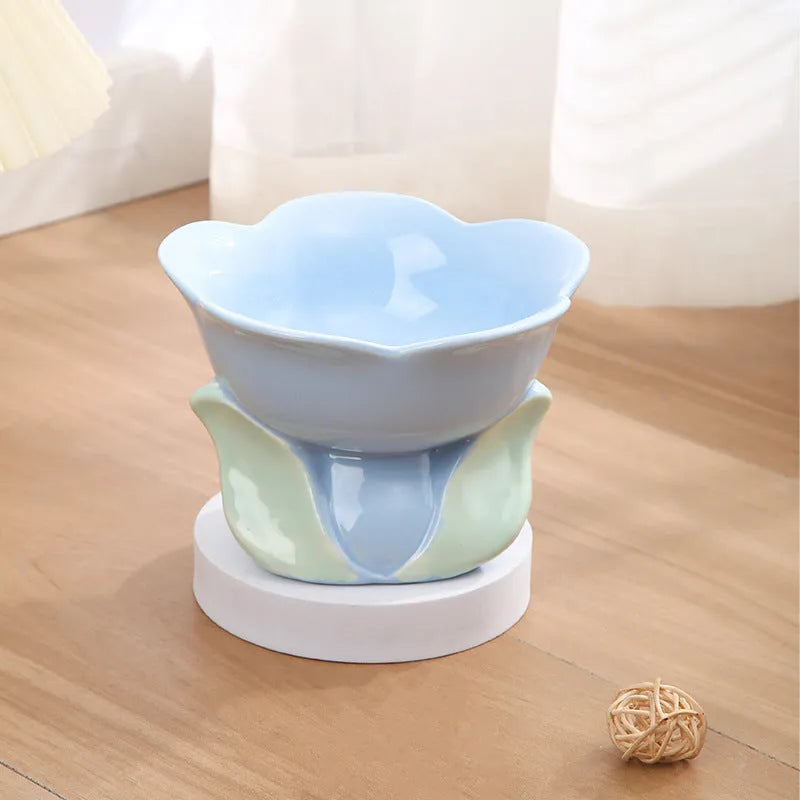 Blue floral patterned ceramic raised pet bowl for cats and dogs on a wooden floor.