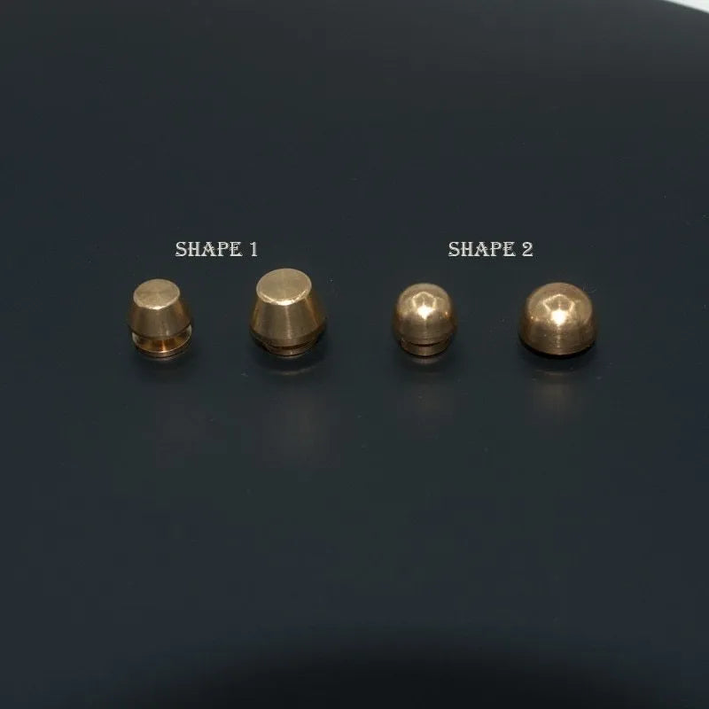 Solid brass decorative buckle for clothing in round and geometric foot nail designs.