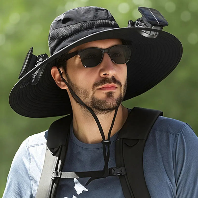 Man wearing a beige wide-brim solar fan hat outdoors, showing the built-in fan and solar panels.