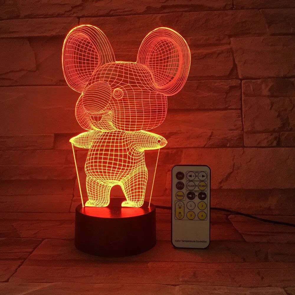 Black koala-shaped LED night light on a table showing multi-colour glow options including red, green, blue, and purple.