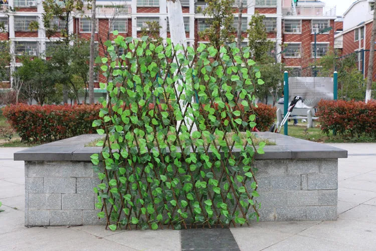 Telescopic garden simulation fence in wood-effect plastic on flowerbed border