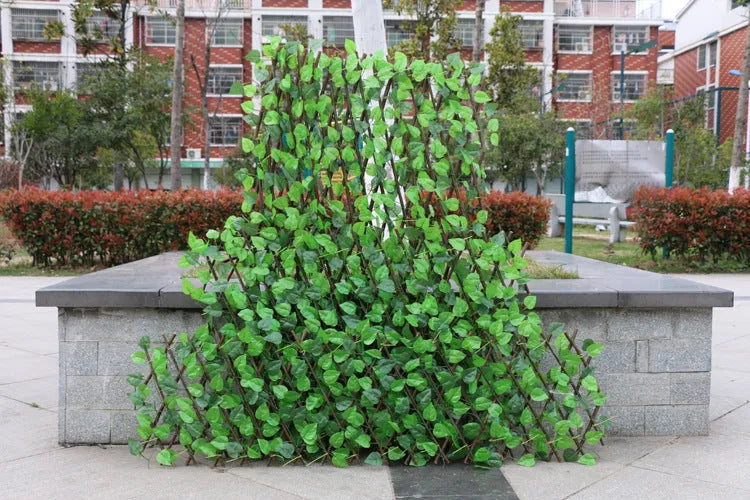 Telescopic garden simulation fence in wood-effect plastic on flowerbed border