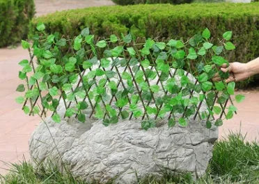 Telescopic garden simulation fence in wood-effect plastic on flowerbed border
