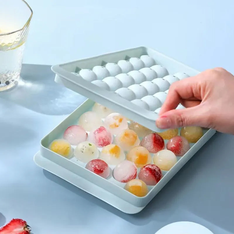 Blue silicone ice cube tray with lid showing 33 round compartments for making ice balls