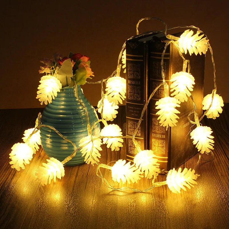 Warm white LED pine cone fairy light string on a green pine branch for decorative lighting