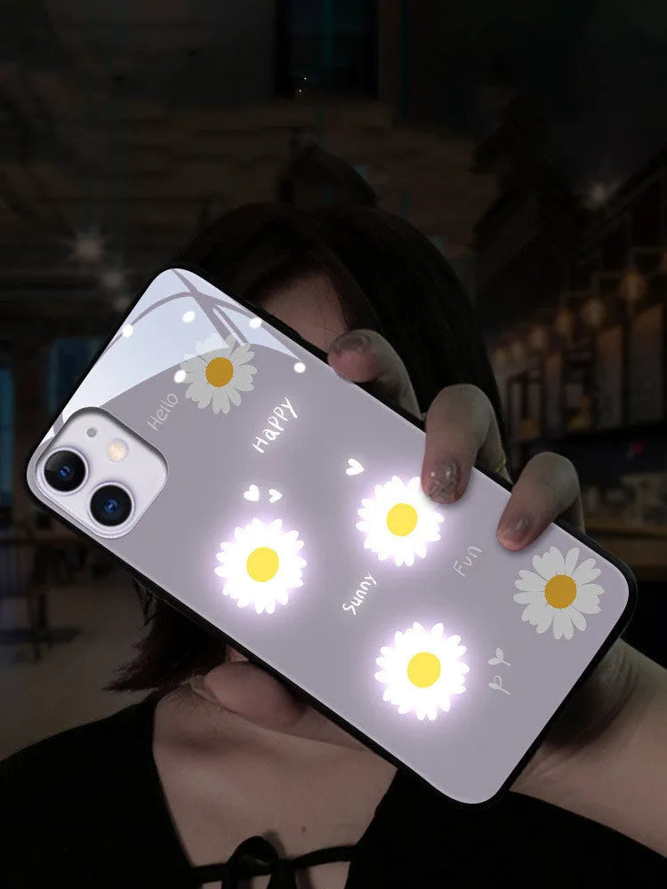 White luminous iPhone case with painted purple daisies and a voice-activated light, shown on a phone.