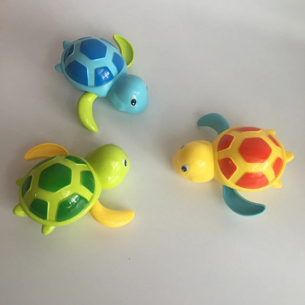 Yellow wind-up plastic turtle water toy on blue surface, 12cm clockwork mechanism