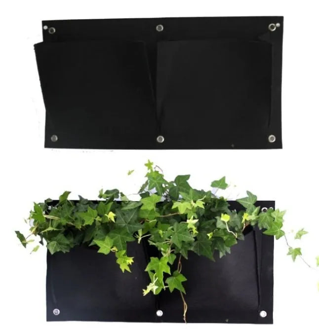 Vertical felt wall garden planting bag with multiple green pockets, hanging on an outdoor fence.