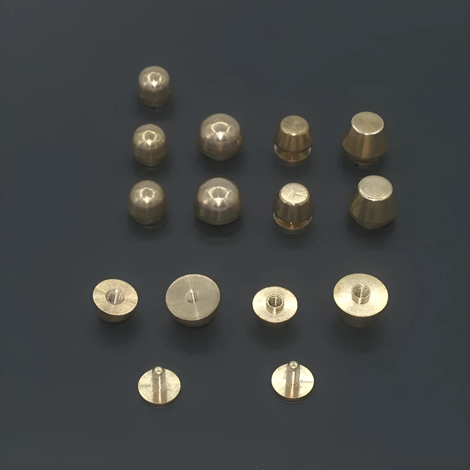 Solid brass decorative buckle for clothing in round and geometric foot nail designs.