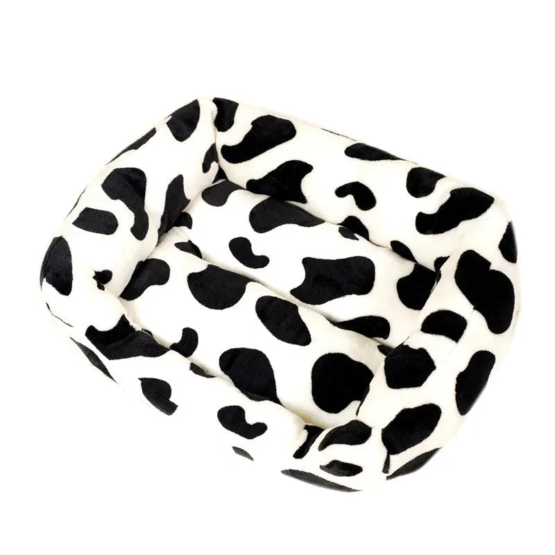 Four Seasons Universal Kennel dog bed in cow colour cloth, size M 40x50cm, with a dog resting on it.