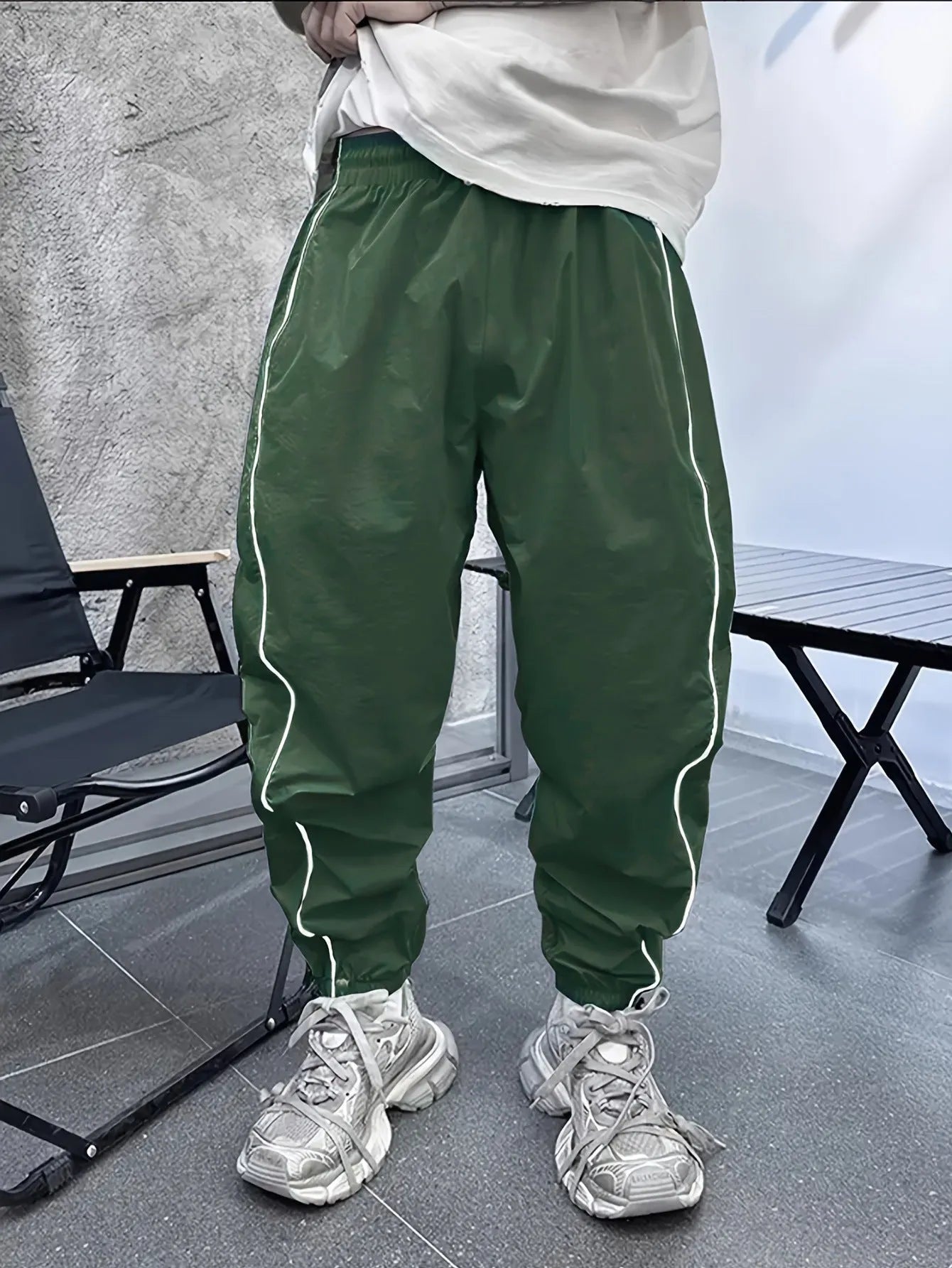Man wearing loose-fit, cropped-length bamboo fibre sports trousers in Army Green colour.