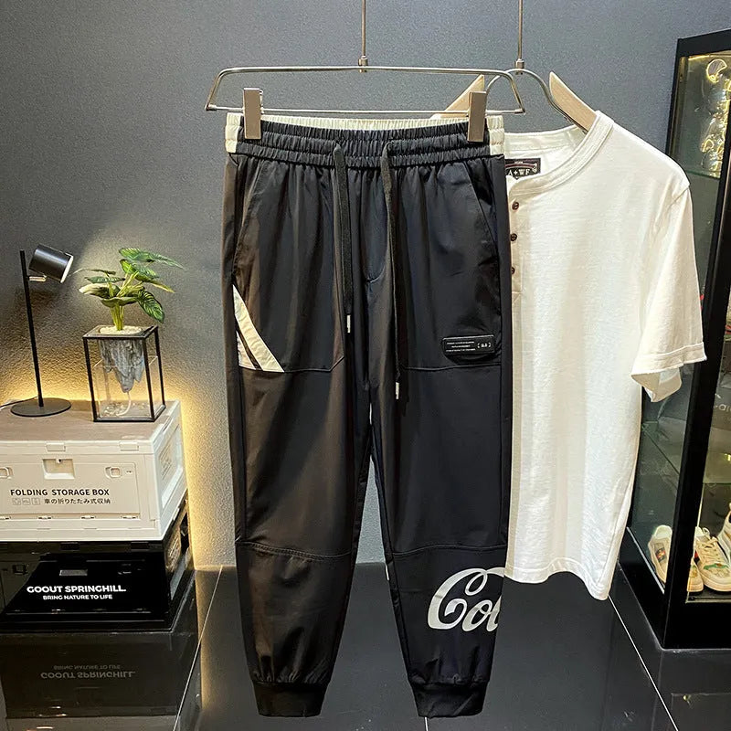 Black men's ultra-thin cotton ankle banded cropped trousers laid flat showing casual design