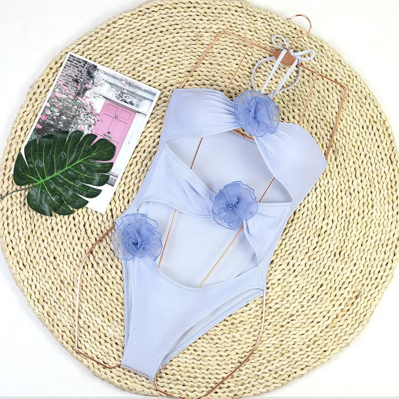 Women's black and blue striped one-piece swimsuit with a 3D flower design