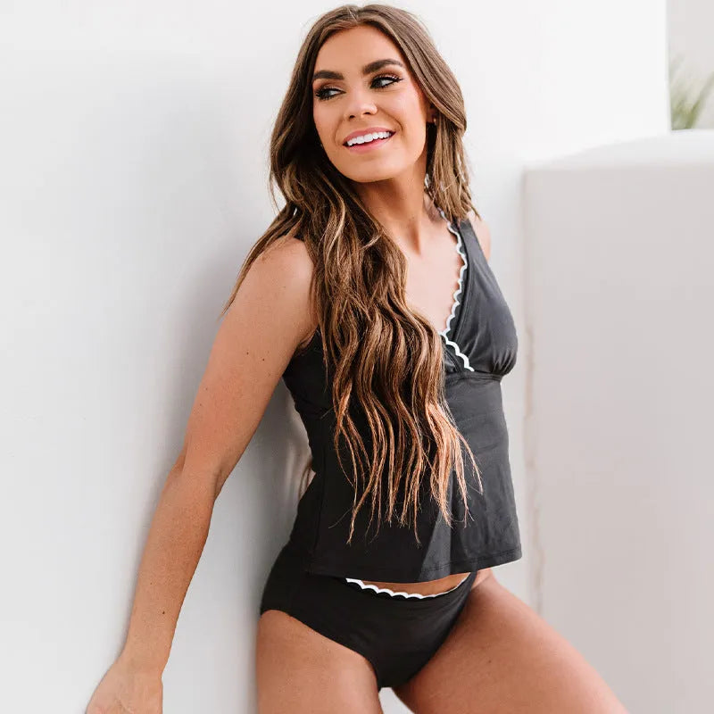 A black one-piece split swimsuit for women on a hanger, showing sleeveless design.