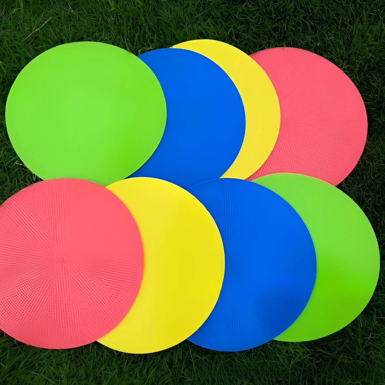 Soft yellow football training target pad, 23cm diameter flat disc on grass.