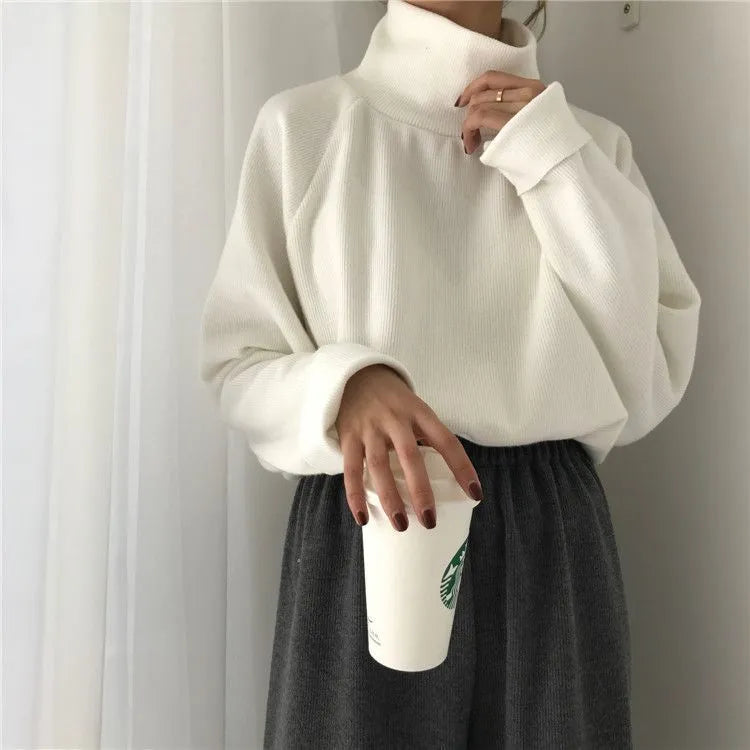 Women's loose fit long sleeve top in solid apricot colour, showing half-high neckline.