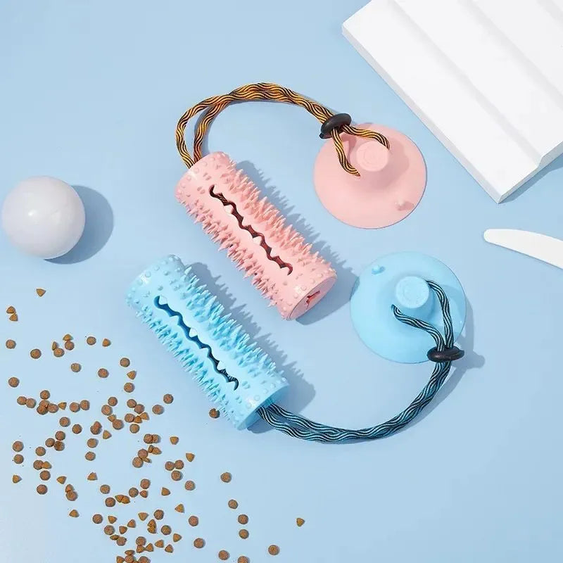 Blue and pink dog chew ball toy with suction cup and food dispenser on tiled floor