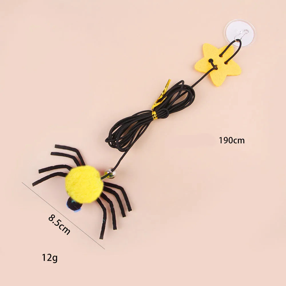 Red cat toy hanging from door with elastic rope, feather stick, bell, and spider decoration