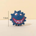 Four colourful squeaky dog balls with cute faces on textured natural latex rubber surfaces