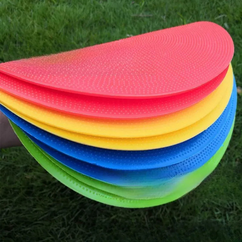 Soft yellow football training target pad, 23cm diameter flat disc on grass.