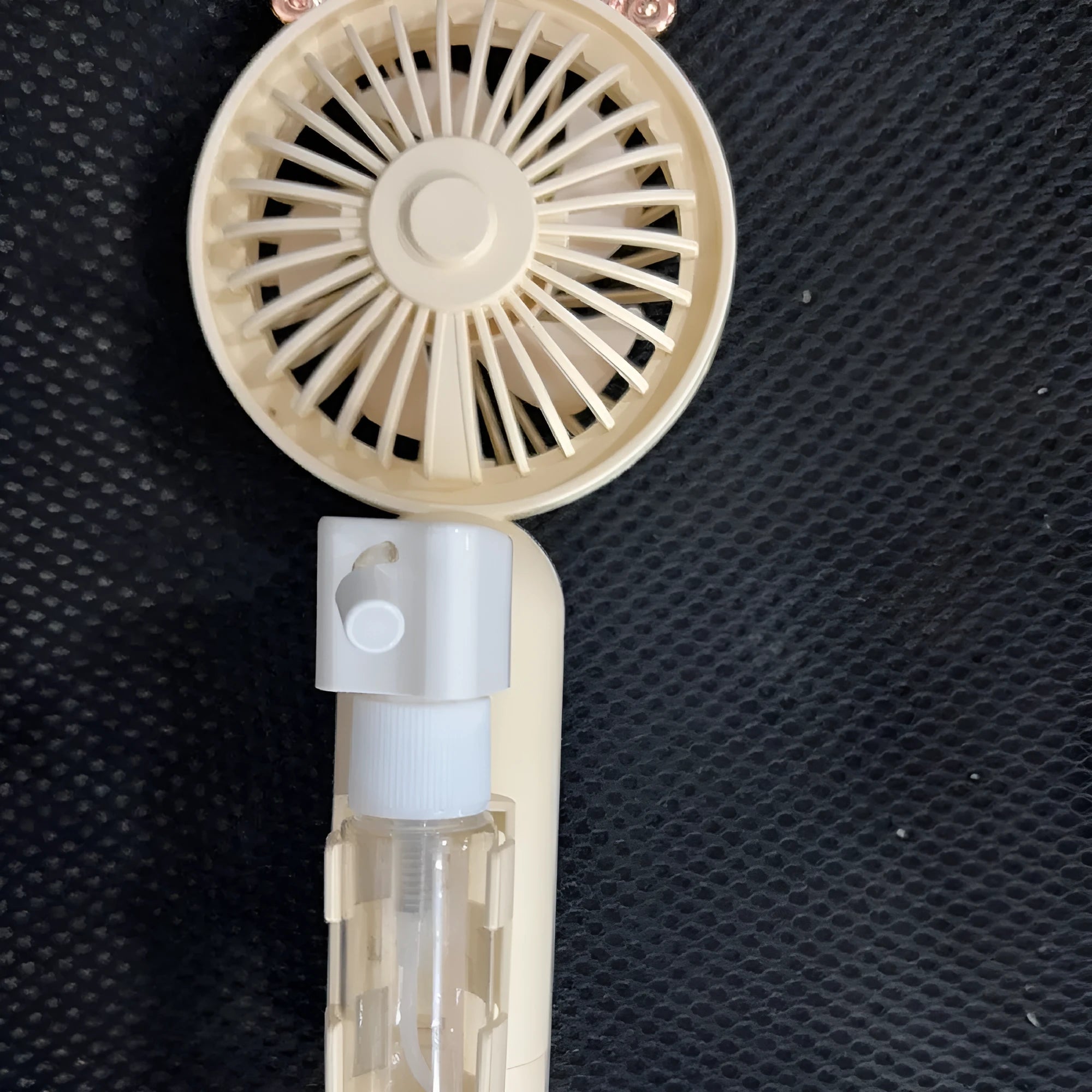 A compact plastic nozzle personal fan in an assortment of colours, showing its USB charging port and slender 6cm width.