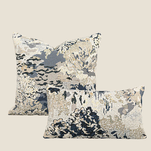 Antique blue abstract floral decorative pillow on a grey sofa, showing square and waist pillow sizes.