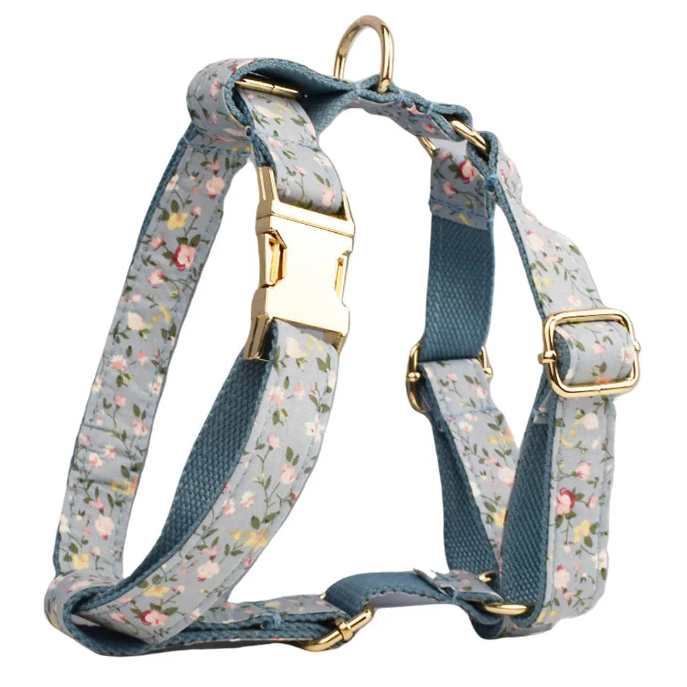 Blue floral pattern dog collar set with matching leash, vest, and accessories on white background
