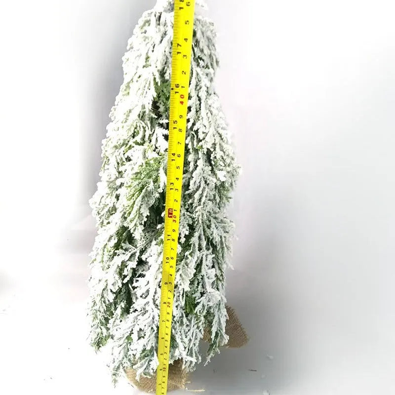 Small 24-inch artificial Christmas tree with white PE snow spray finish, green branches, built-in lights, and a red ornament