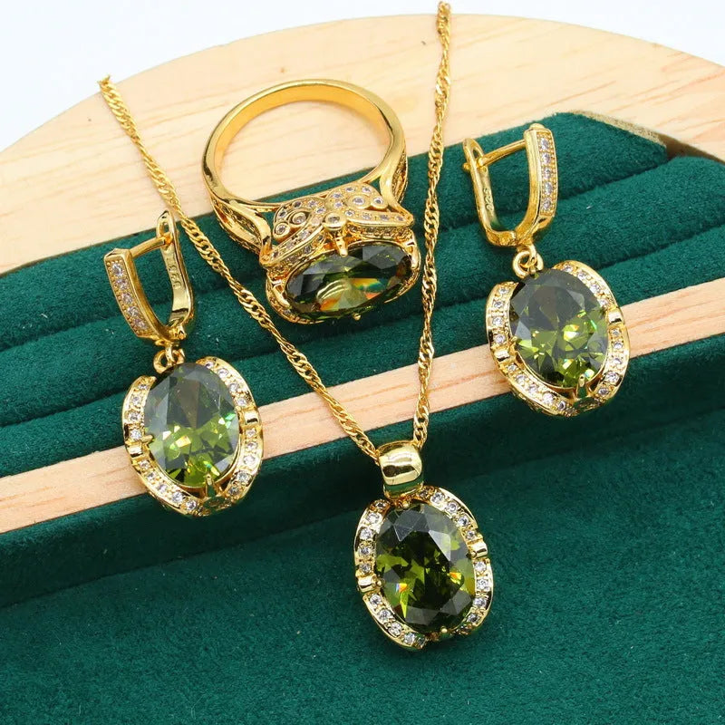 Olive green rhinestone jewellery set with necklace, earrings and ring featuring cross, crown and numeral designs.
