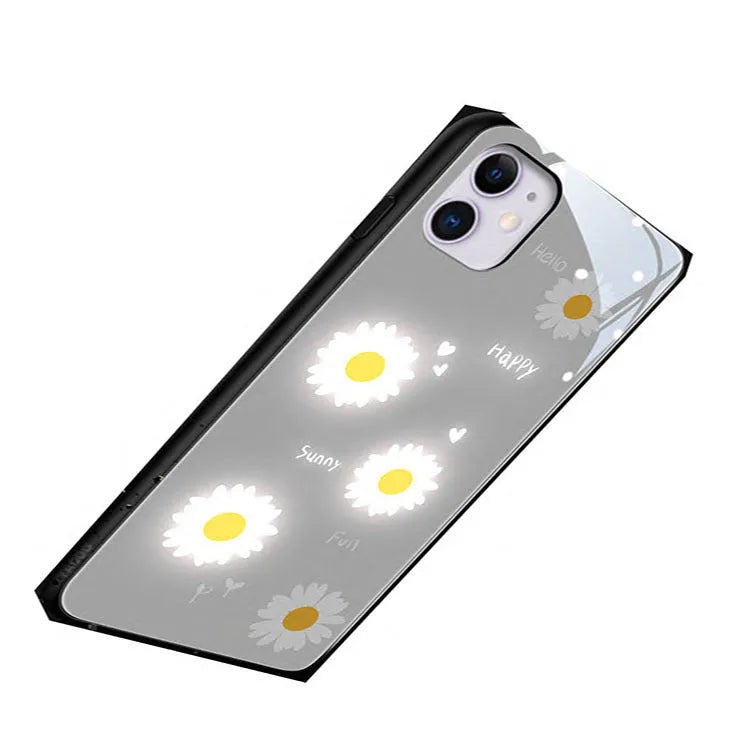 White luminous iPhone case with painted purple daisies and a voice-activated light, shown on a phone.