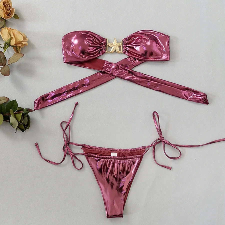 Women's glossy sapphire blue bikini with gold starfish print, showing backless two-piece design.