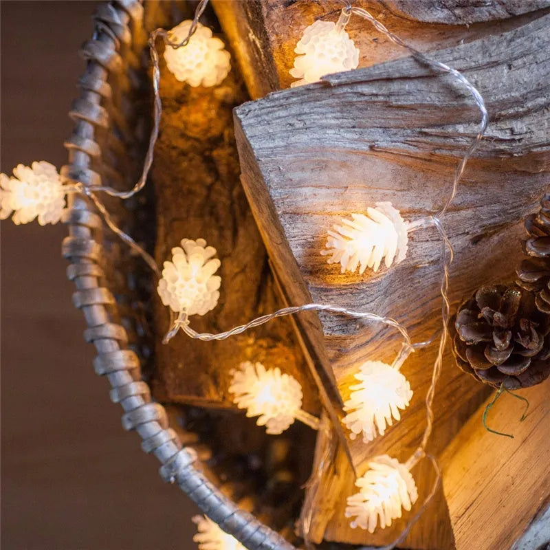 Warm white LED pine cone fairy light string on a green pine branch for decorative lighting