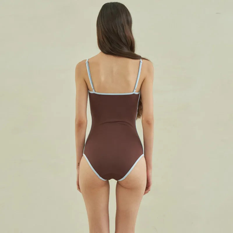 Brown women's triangle one-piece swimsuit with a pattern, shown on a hanger