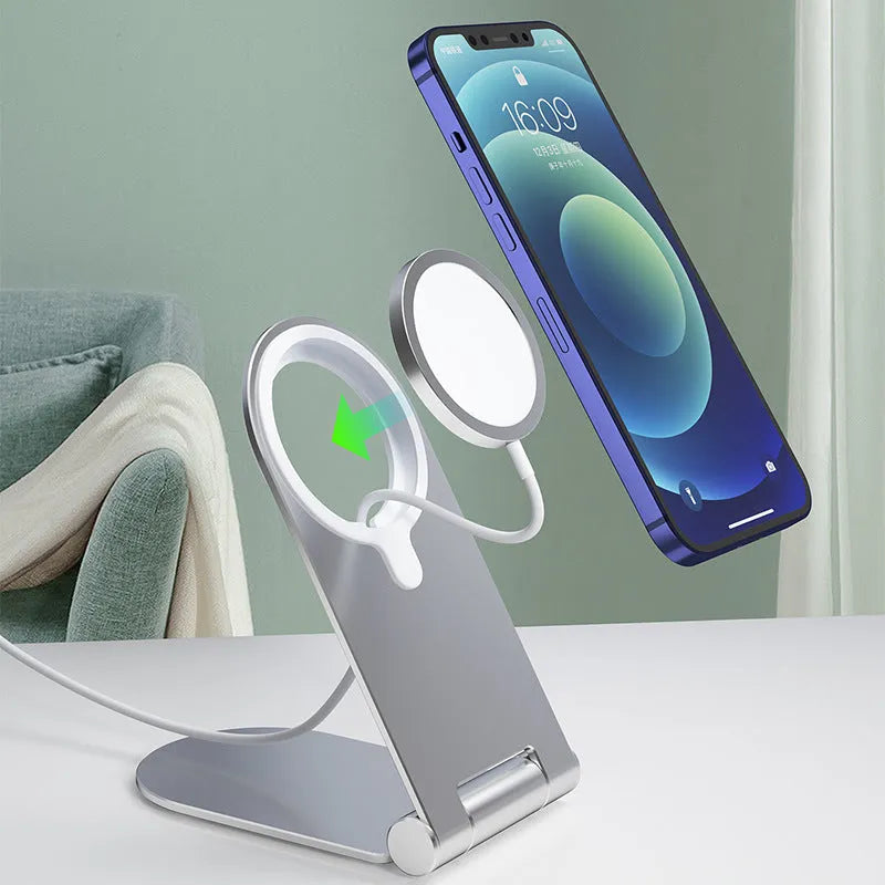 Silver vertical adjustable magnetic phone bracket for iPhone 12 models on a desk.