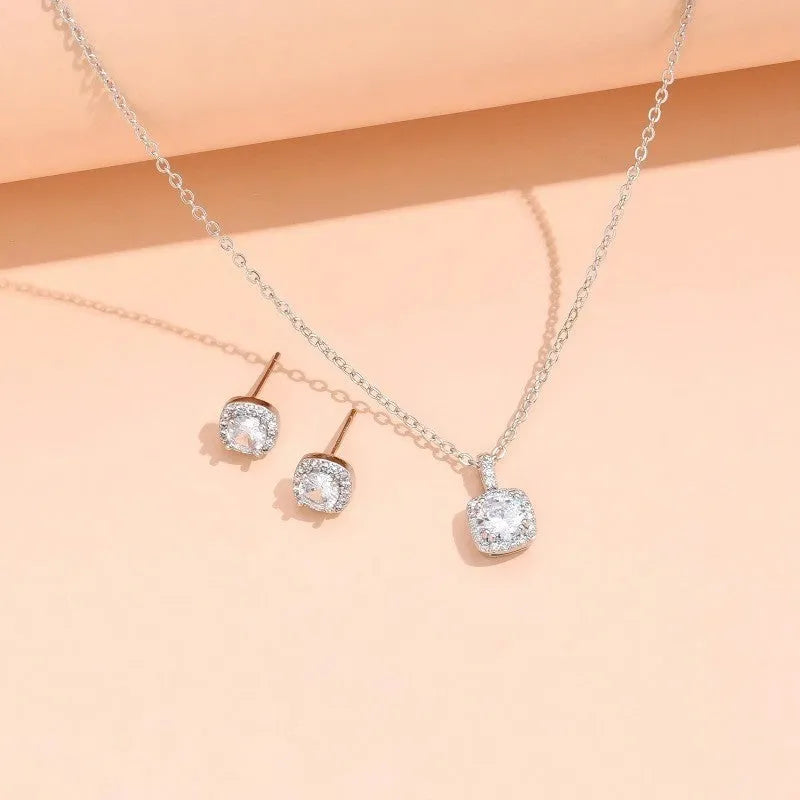 Women's minimalist square cubic zirconia necklace and earring set in gold finish on a light background