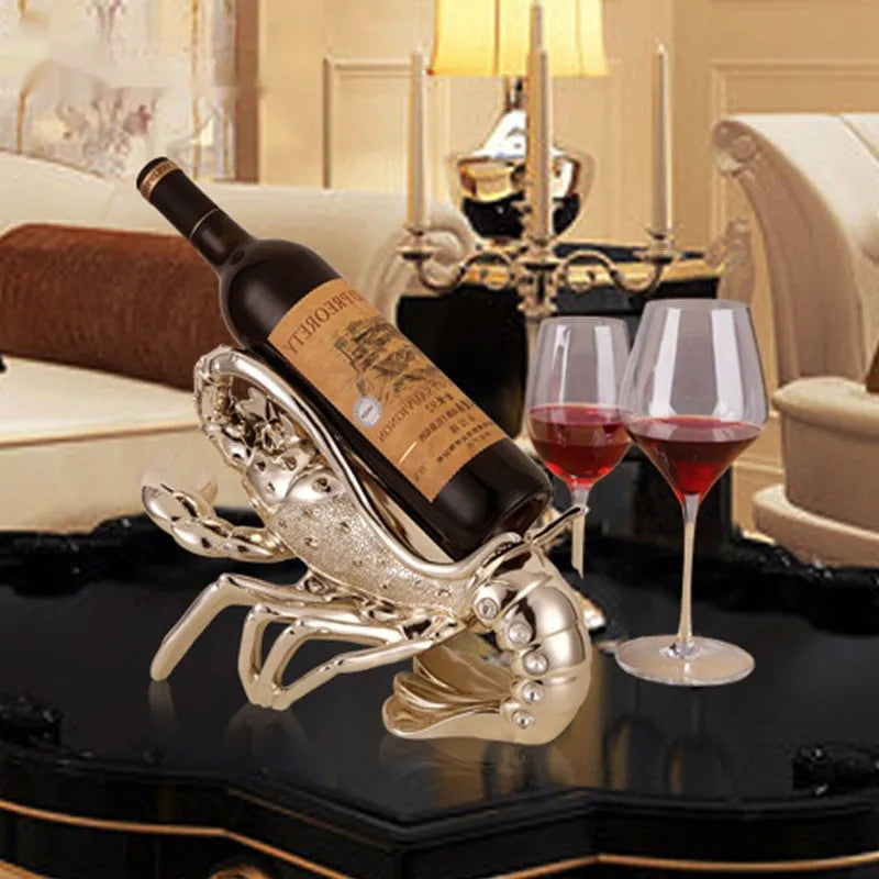 Lobster-shaped natural resin wine rack ornament in rose gold or silver colour on a table.